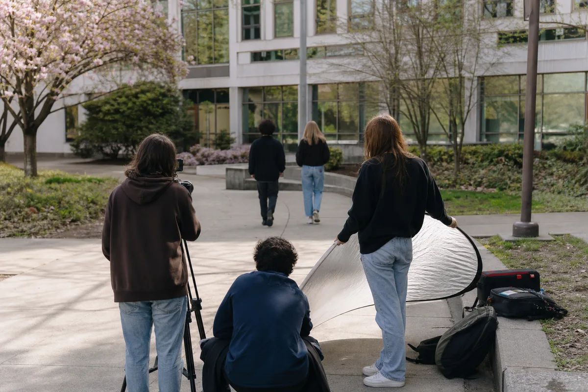 Étudiants en audiovisuel filmant une courte scène avec une caméra sur trépied